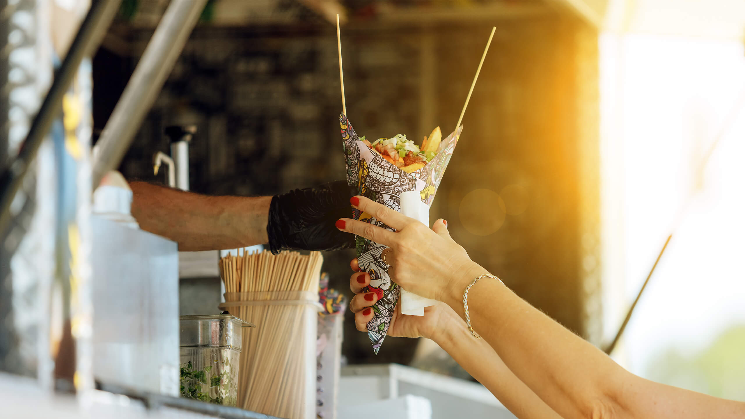 Food truck attendee handing meal to customer